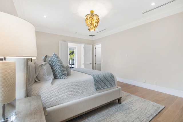 bedroom with ornamental molding and hardwood / wood-style flooring