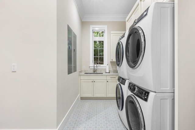 clothes washing area with cabinets, crown molding, sink, and stacked washing maching and dryer