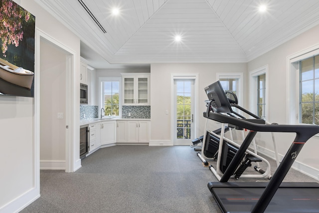 workout room with lofted ceiling, sink, wood ceiling, and a healthy amount of sunlight