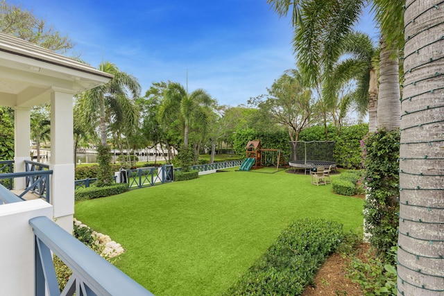 view of yard with a playground and a trampoline