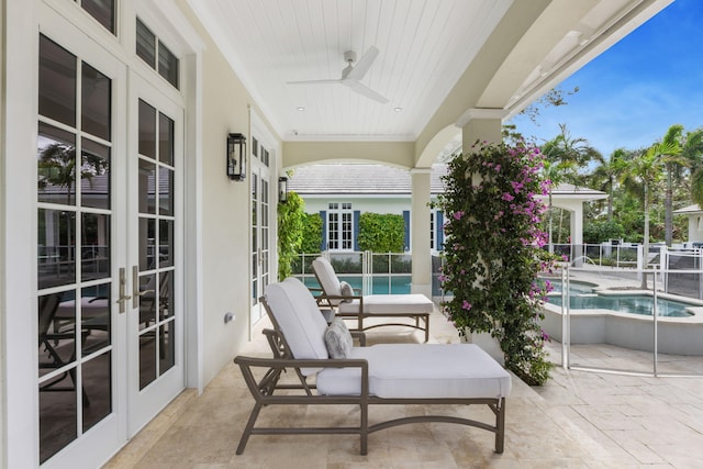 view of patio / terrace with a fenced in pool, ceiling fan, and french doors