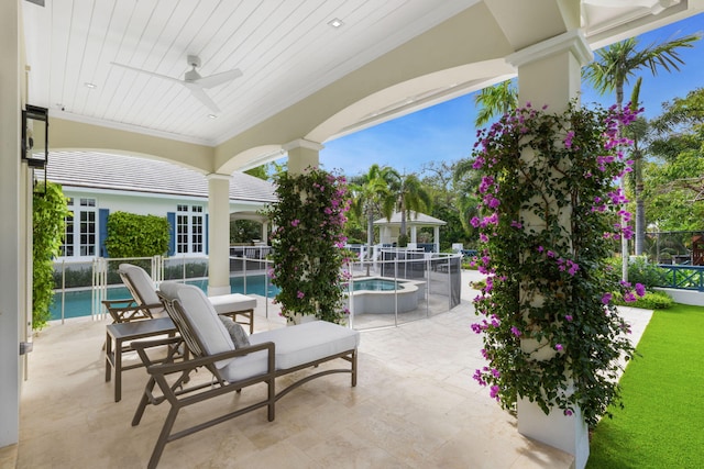 view of patio / terrace featuring ceiling fan and a swimming pool with hot tub