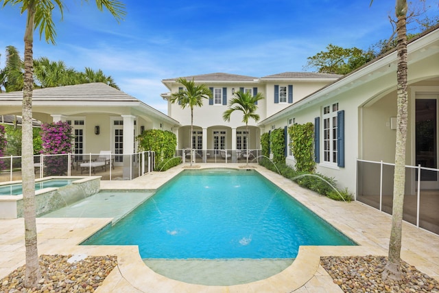 view of swimming pool featuring pool water feature, a patio, and an in ground hot tub