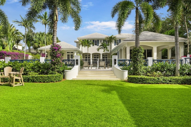 rear view of property featuring a lawn