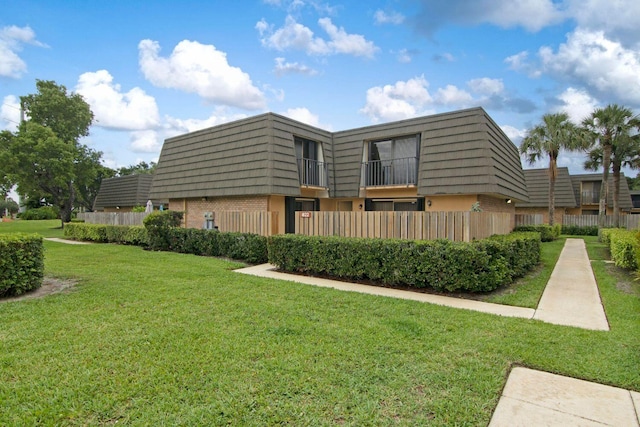 exterior space featuring a balcony and a yard