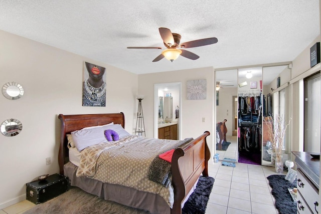 tiled bedroom with ensuite bathroom, a closet, a textured ceiling, and ceiling fan