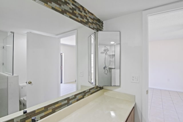 bathroom featuring vanity, an enclosed shower, toilet, tile patterned flooring, and backsplash