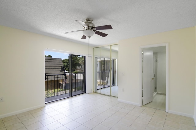 tiled spare room featuring a textured ceiling and ceiling fan