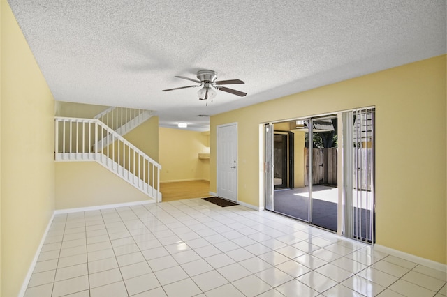 spare room featuring light tile patterned flooring, a textured ceiling, and ceiling fan