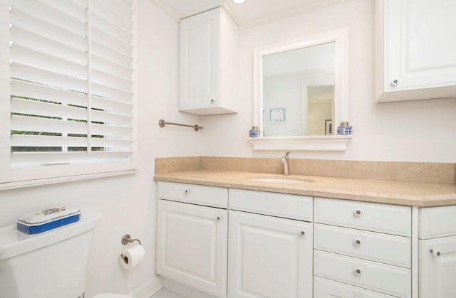 bathroom featuring vanity, toilet, and ornamental molding