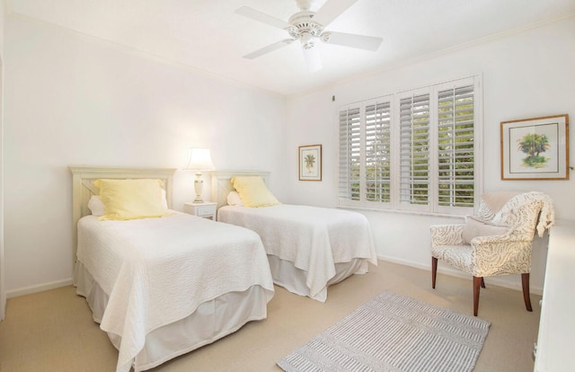 carpeted bedroom with ceiling fan and ornamental molding