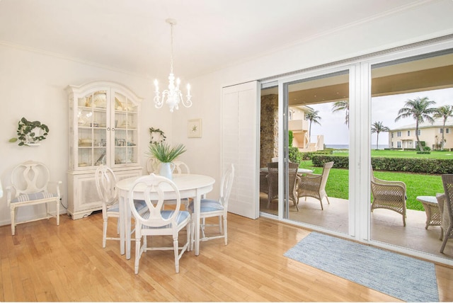 dining room featuring a notable chandelier, crown molding, and light hardwood / wood-style floors