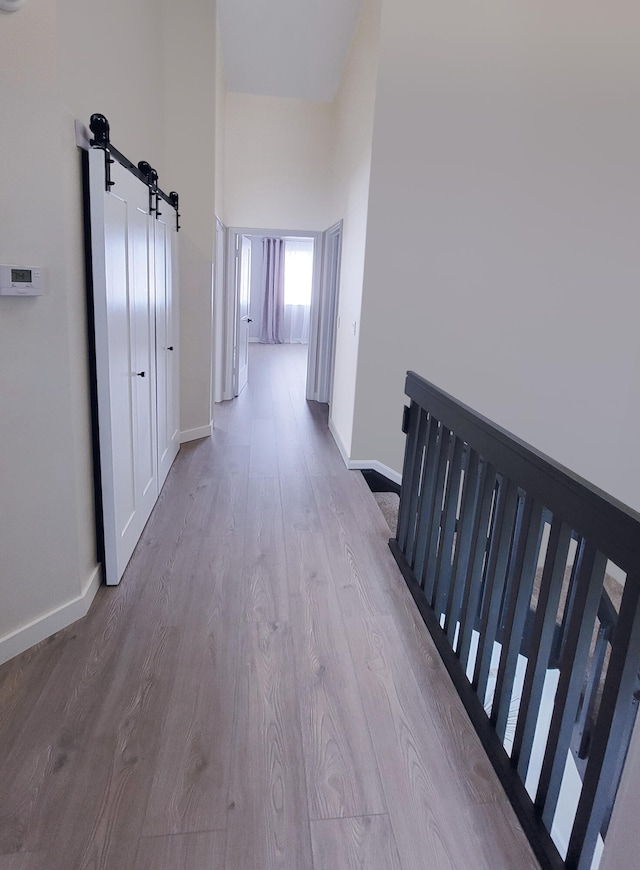 hallway featuring light hardwood / wood-style flooring and a barn door