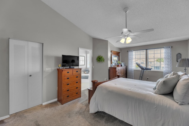 bedroom with ceiling fan, a closet, vaulted ceiling, light colored carpet, and a textured ceiling