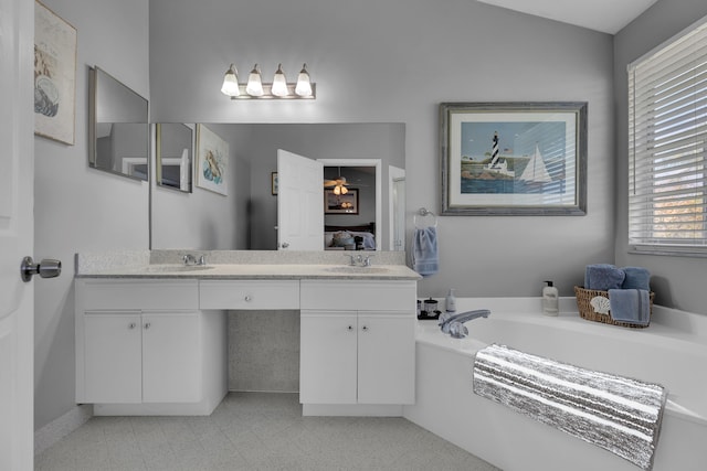 bathroom with vaulted ceiling, vanity, and a bathing tub