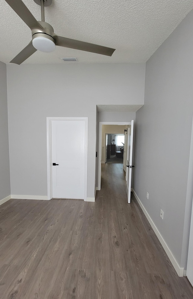 spare room with ceiling fan, a textured ceiling, and dark hardwood / wood-style flooring