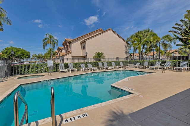 view of swimming pool featuring a community hot tub and a patio area