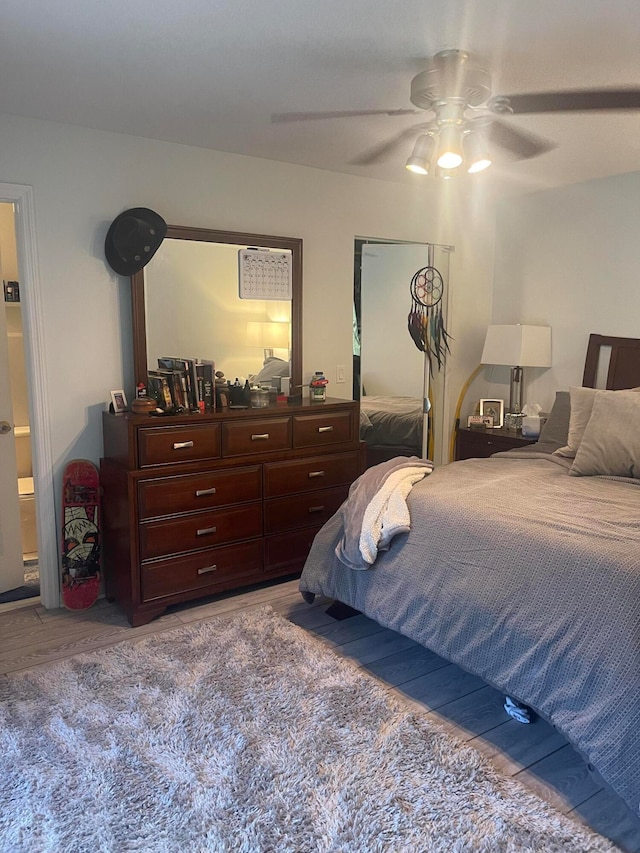 bedroom featuring hardwood / wood-style flooring, ceiling fan, and ensuite bath