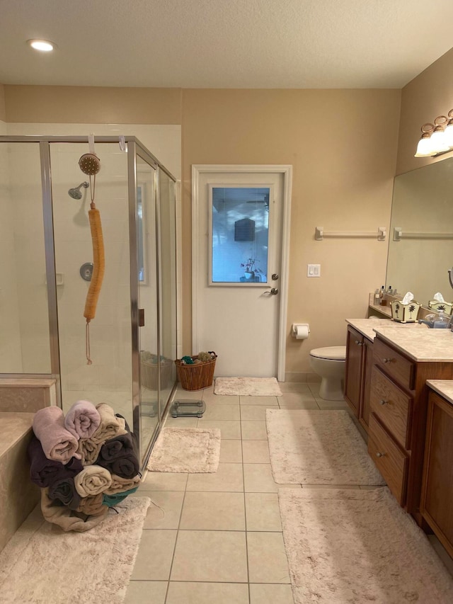 bathroom with tile flooring, walk in shower, vanity, and toilet