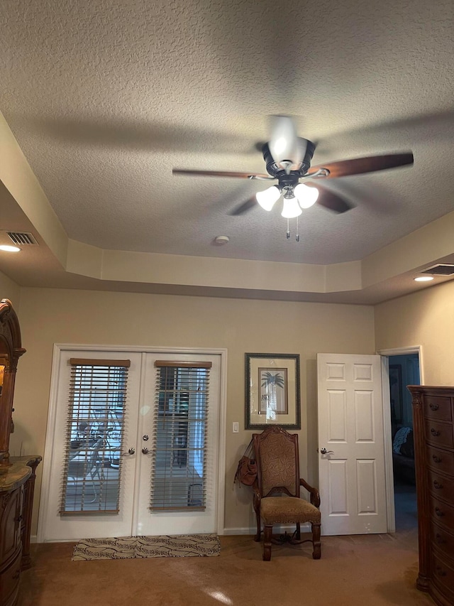 unfurnished room featuring a tray ceiling, french doors, carpet floors, and ceiling fan