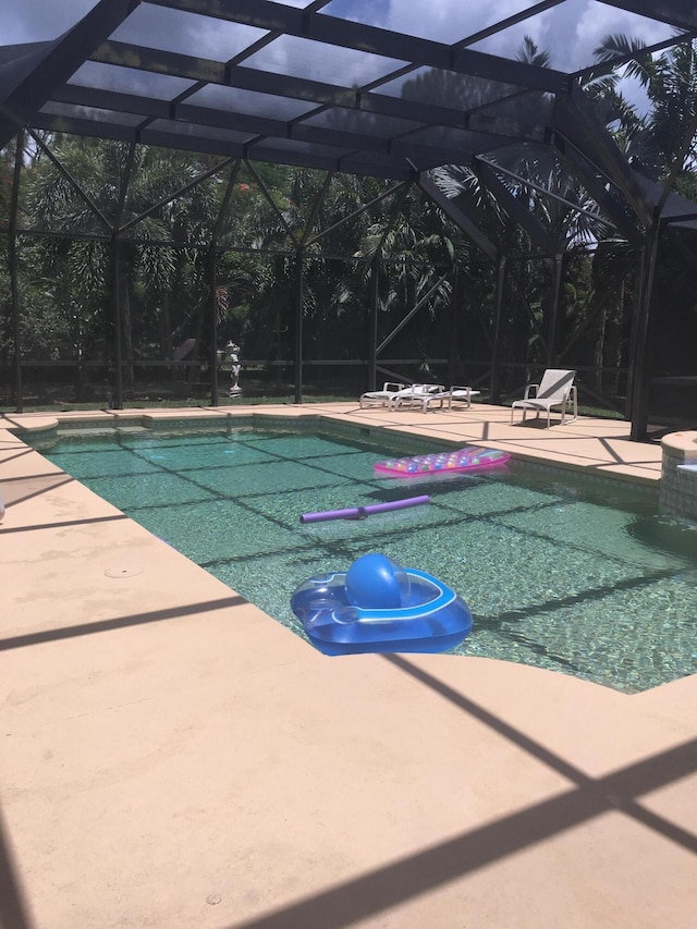 view of pool featuring a patio and glass enclosure