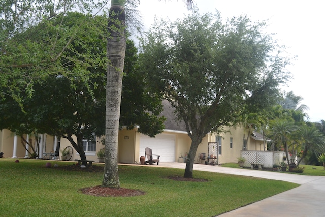 obstructed view of property featuring a front lawn and a garage