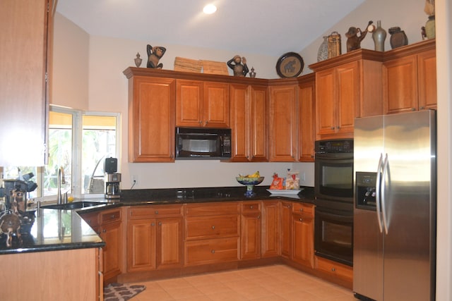 kitchen with black appliances, dark stone counters, vaulted ceiling, sink, and light tile floors