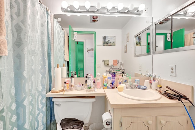 bathroom with large vanity and toilet