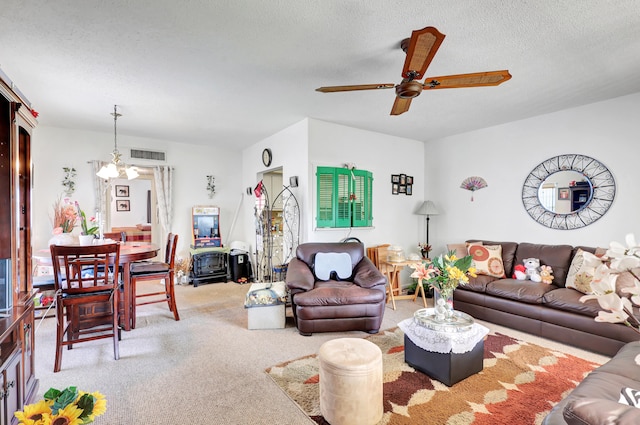 carpeted living room with a textured ceiling and ceiling fan with notable chandelier