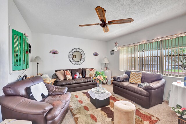 carpeted living room with ceiling fan and a textured ceiling