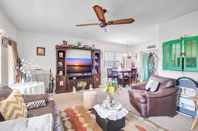 carpeted living room with a textured ceiling and ceiling fan with notable chandelier