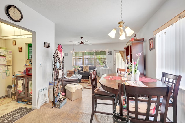 dining area featuring a textured ceiling and ceiling fan with notable chandelier