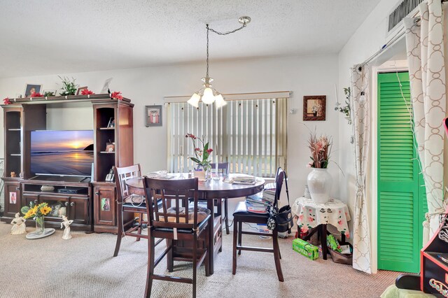 carpeted dining area featuring a textured ceiling and a chandelier