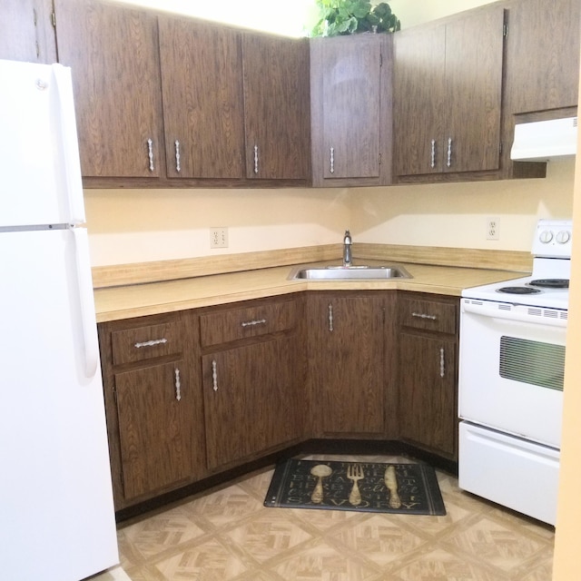 kitchen featuring white appliances, dark brown cabinets, and sink