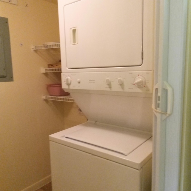 washroom featuring stacked washing maching and dryer and electric panel