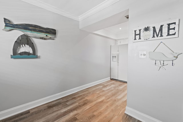 hallway with light hardwood / wood-style floors and crown molding