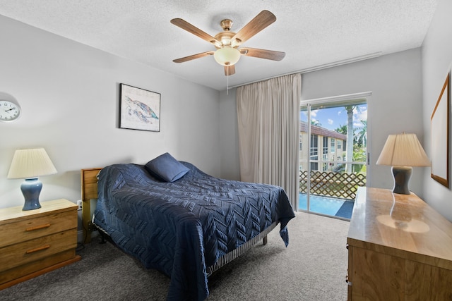 bedroom featuring access to outside, a textured ceiling, dark colored carpet, and ceiling fan