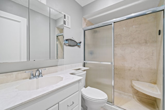 bathroom featuring vanity, a shower with shower door, and toilet