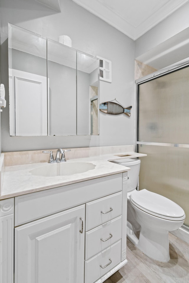 bathroom with toilet, ornamental molding, and vanity