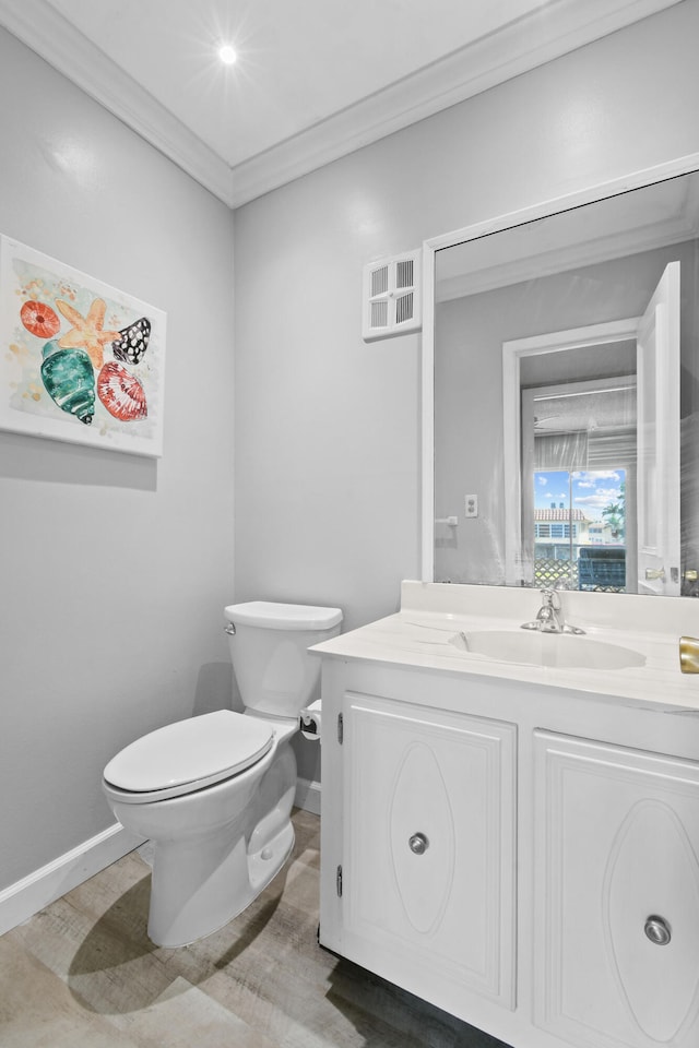 bathroom with toilet, vanity, and crown molding