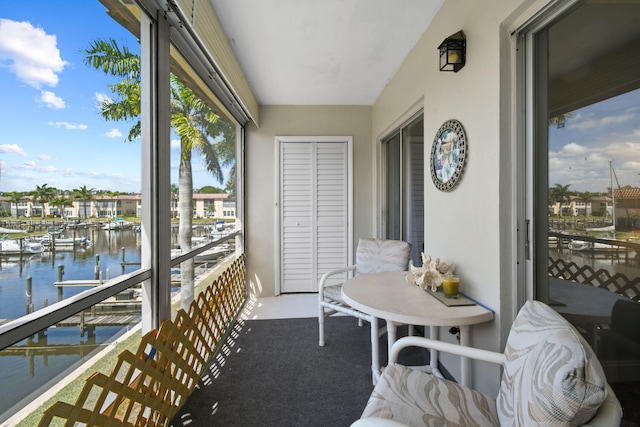 sunroom featuring a water view