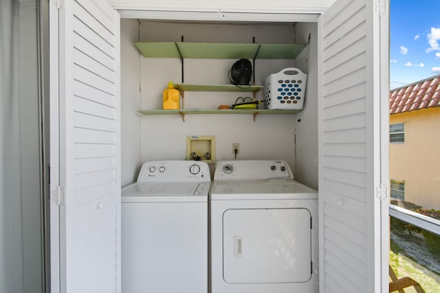 clothes washing area with washer hookup, washing machine and dryer, and a wealth of natural light