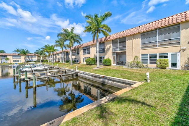 view of dock with a yard and a water view