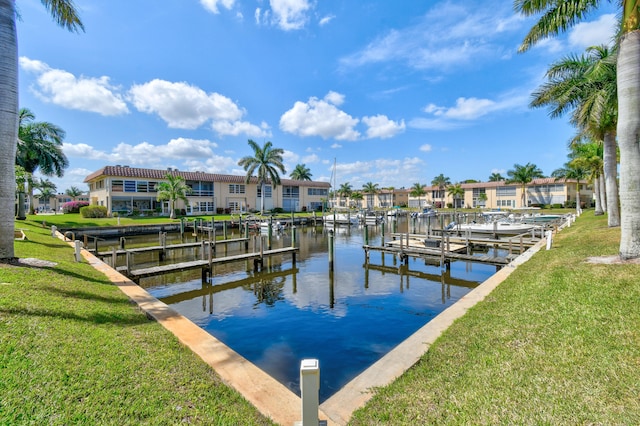 view of dock with a lawn and a water view