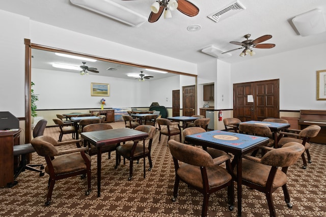 carpeted dining area with ceiling fan