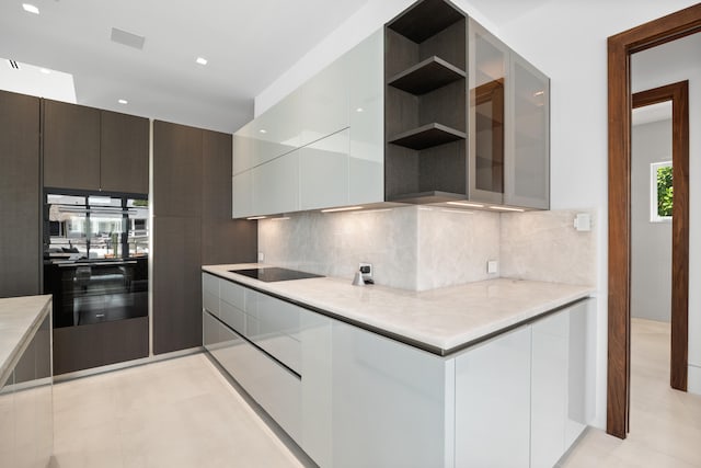 kitchen with backsplash, light tile flooring, and white cabinets