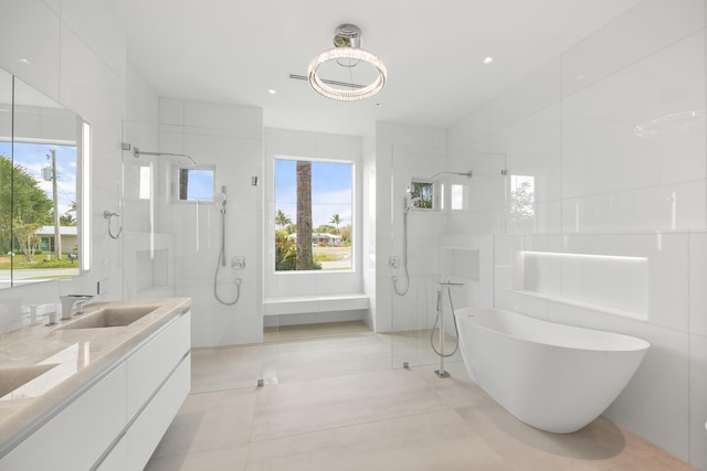 bathroom featuring shower with separate bathtub, large vanity, a wealth of natural light, and tile flooring