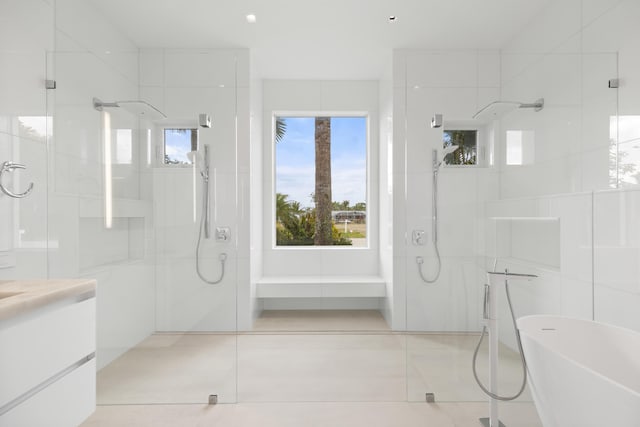 bathroom with tile walls, shower with separate bathtub, tile floors, and vanity