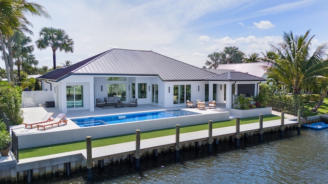 rear view of house featuring a water view, a patio, and a fenced in pool