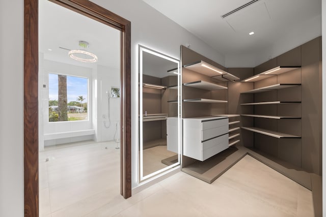 walk in closet with light tile flooring